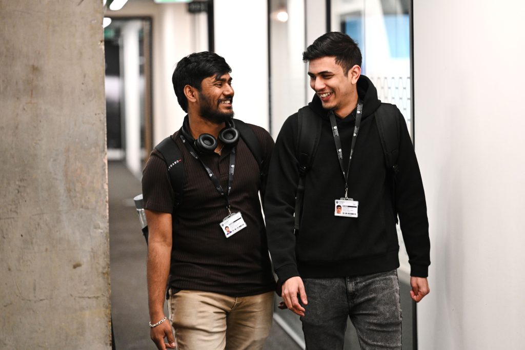Two students walking down a corridor